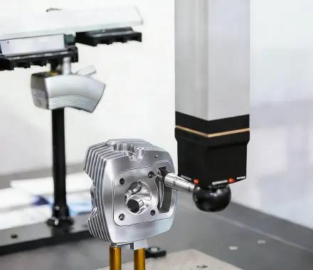 Technician measuring a small metal stamped part with a handheld digital gauge